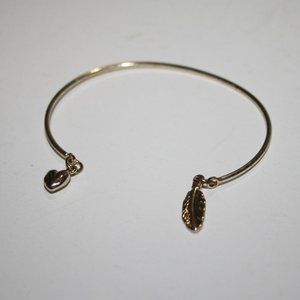 Gold cuff bracelet with feather and heart